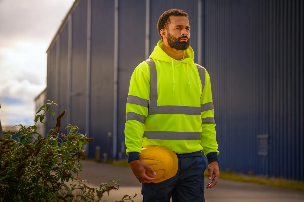 Yellow reflective PRO RTX hoodie worn outside an industrial building